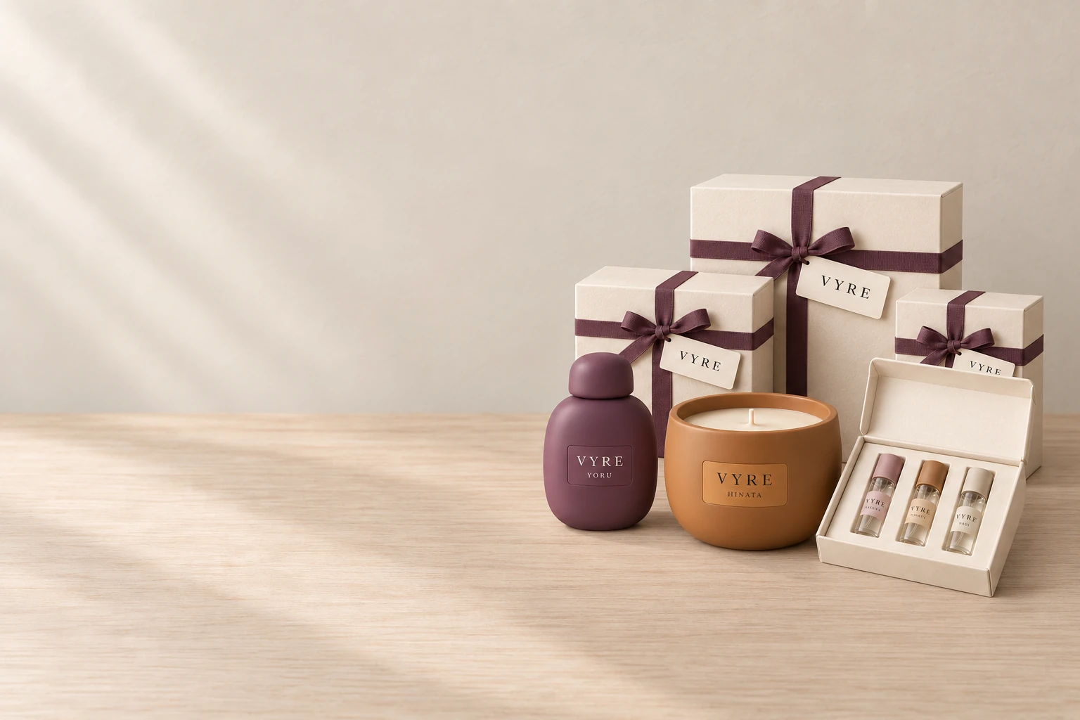Drei VYRE-Geschenkschachteln mit Band in Pflaume, davor YORU Eau de Parfum, eine HINATA-Kerze und ein Probenset