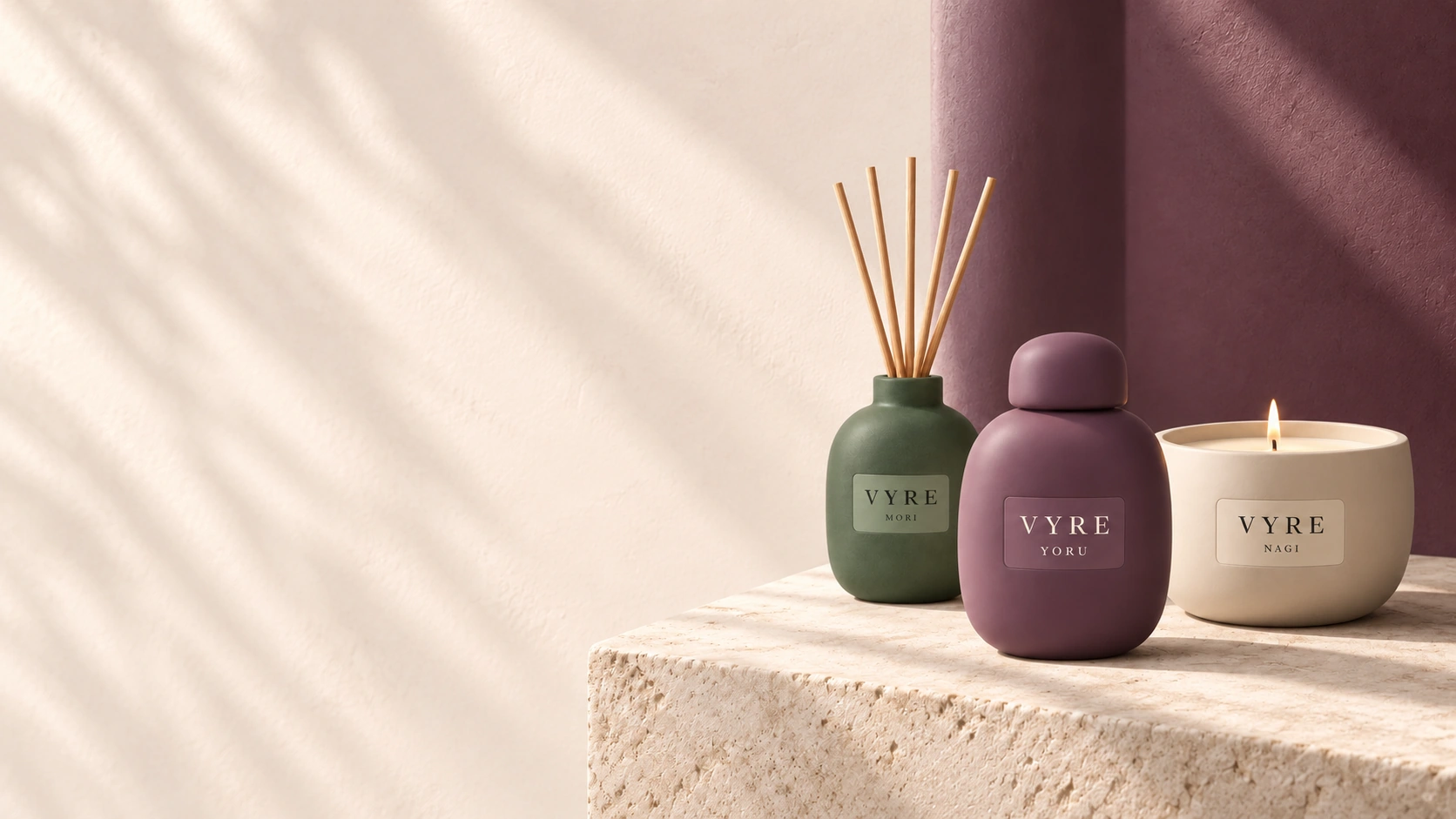 YORU Eau de Parfum, MORI-Duftstäbchen und eine brennende NAGI-Kerze auf hellem Stein vor pflaumenfarbener Wand